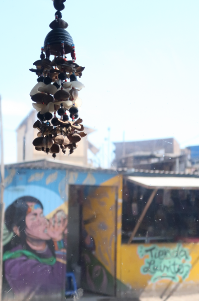 Ozdoba wykonana z muszli i skorupek na tle budynku pokrytego muralami